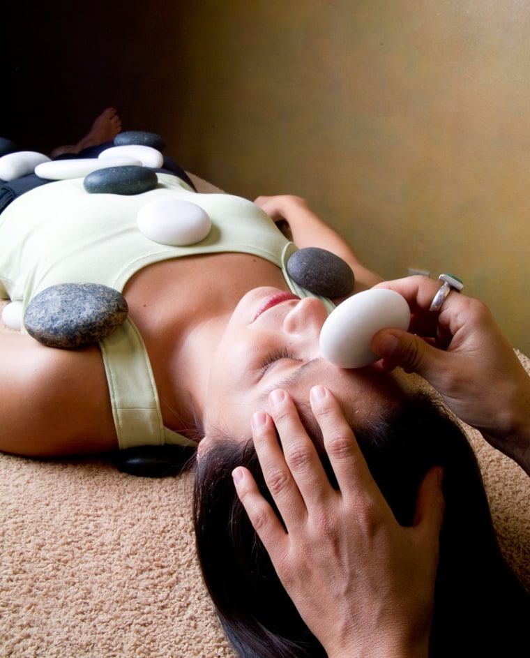 A model is given a therapeutic stone massage using heated black basalt stones and cool white marble stones at the Miraval Life in Balance Spa in Catalina, Ariz.